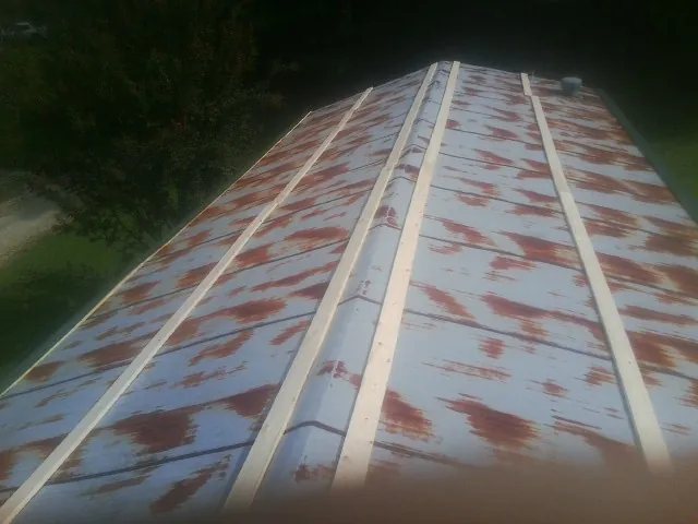 Rusted metal roof panels with new wood purlins before replacement — Storm Damage Roof Repair in Houston by Roofing Brothers